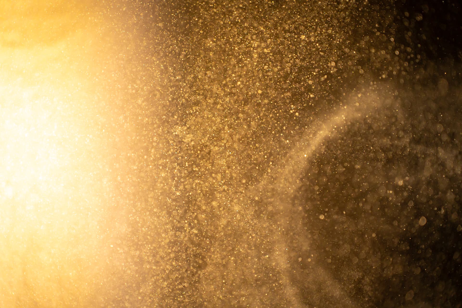 Fine dust particles suspended and lit by golden light