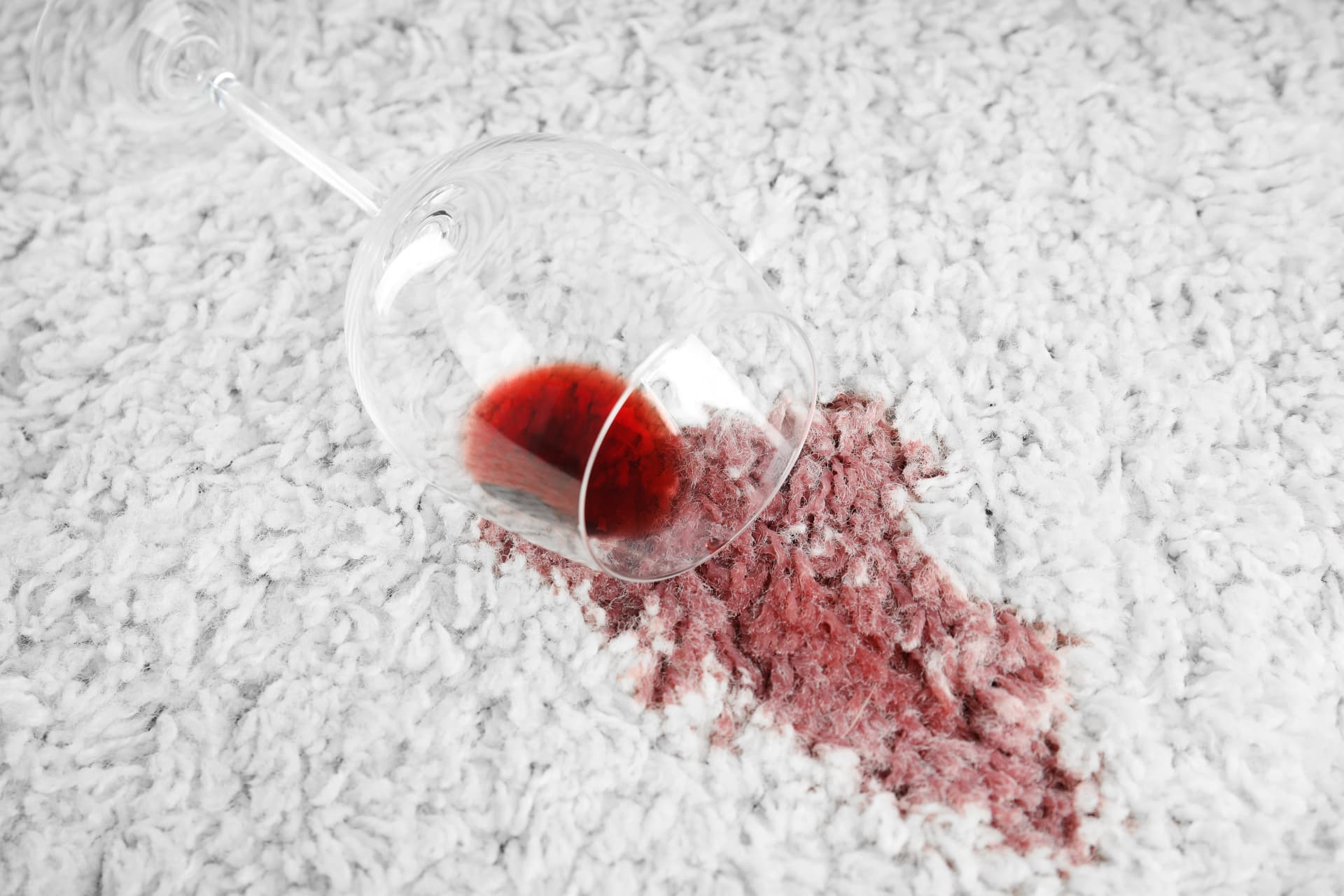Spilled glass of red wine staining a light coloured carpet